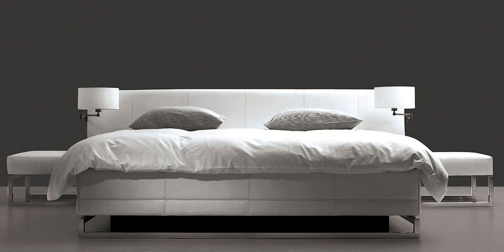 Ein weißes Bett in einem dunklen Raum aus der Serie Akva