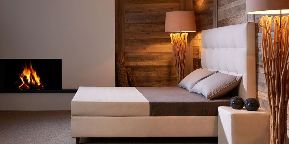 Ein weißes Bett in einem Raum mit Holzfassade