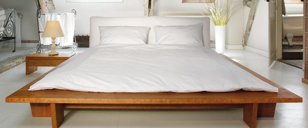 Sira Massivholzbett steht niedrig in einem Raum