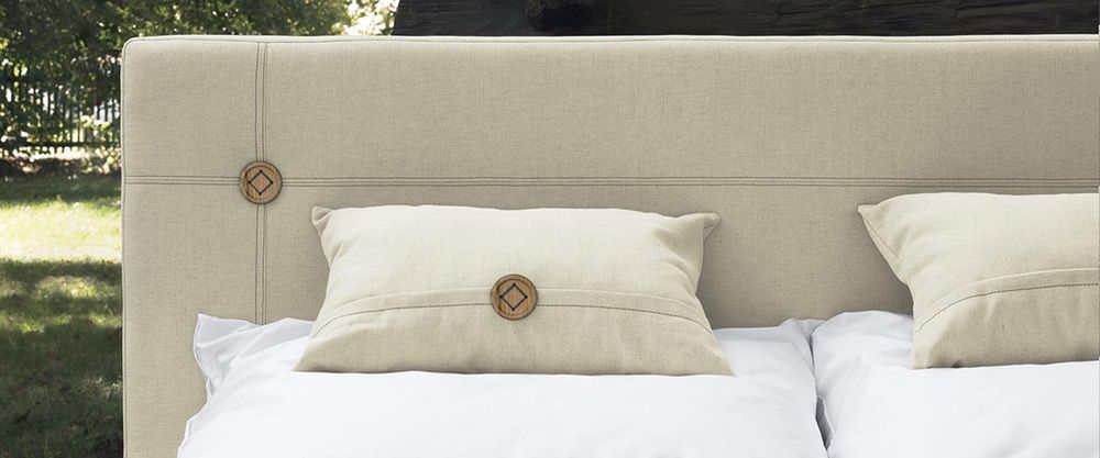 Beige Kissen auf einem Boxspringbett